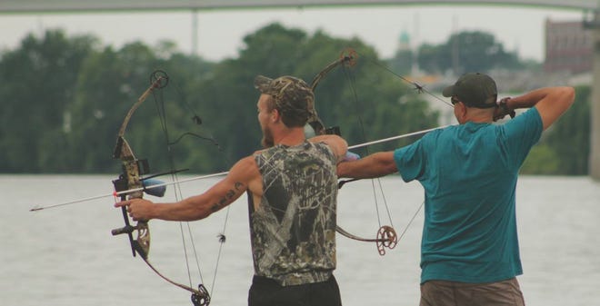 A pair of bow fisherman watch for Asian carp during the tournament in East Peoria Saturday.