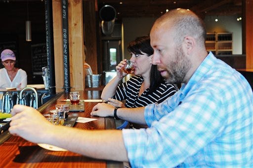 Susan Edwards and Chris Edwards, both of Westboro, Mass., sample wines Monday at Prairie Berry East Bank in downtown Sioux Falls, S.D.