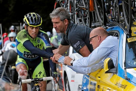 AP PHOTO
Spain's Alberto Contador gets assistance from his team after crashing during the tenth stage of the Tour de France cycling race over 161.5 kilometers (100.4 miles) with start in Mulhouse and finish in La Planche des Belles Filles, France on Monday. Contador withdrew from the race as a result of the crash. At right is his team manager, Bjarne Riis of Denmark.