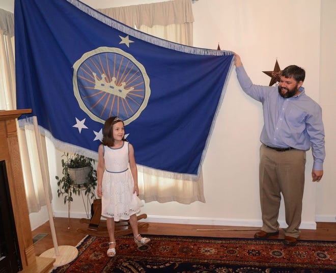 Jeremiah Heaton and his seven year-old daughter, Princess Emily, show the flag,July 2, 2014, in Abingdon, Va, that their family designed as they try to claim a piece of land in the Eastern African region of Bir Tawil.