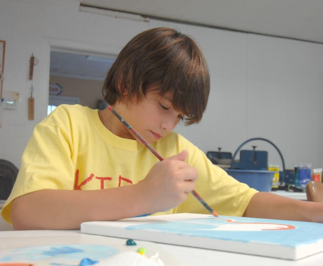 Ben Harkins works on his painting of a flamingo Wednesday during the Arts and Design Society’s Kids Art Camp in Fort Walton Beach.