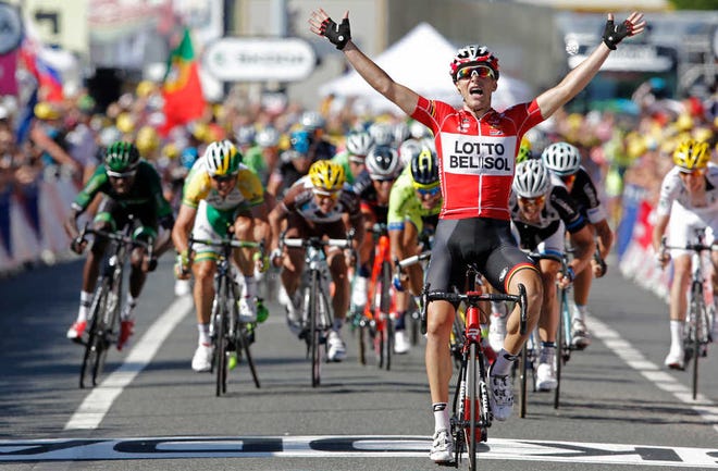 France's Tony Gallopin manages to stay ahead of the spring pack, rear, as he crosses the finish line to win the eleventh stage of the Tour de France cycling race over 187.5 kilometers (116.5 miles) with start in Besancon and finish in Oyonnax, France, Wednesday, July 16, 2014. (AP Photo/Peter Dejong)
