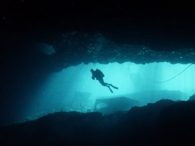 A diver swims across the grotto at Blue Grotto in Williston.