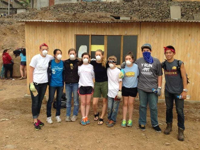 On the service trip to Peru through the Y, Evie (third from left) and other students painted this schoolhouse.