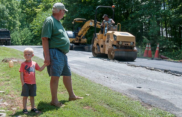 John Stauffer and his grandson Noah Stauffer,3, check out road work being done on Westminster Court, near John Stauffer's home 7.17.14. 
 A Randolph County School bus makes its way through the new roundabout near Randleman Middle School on the first day of school August 25 2010.(PAUL CHURCH / THE COURIER-TRIBUNE)