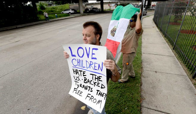 David J. Phillip/The Associated PressBill Lambert holds a sign on Friday as he joins demonstrators outside the Mexican Consulate in Houston.
