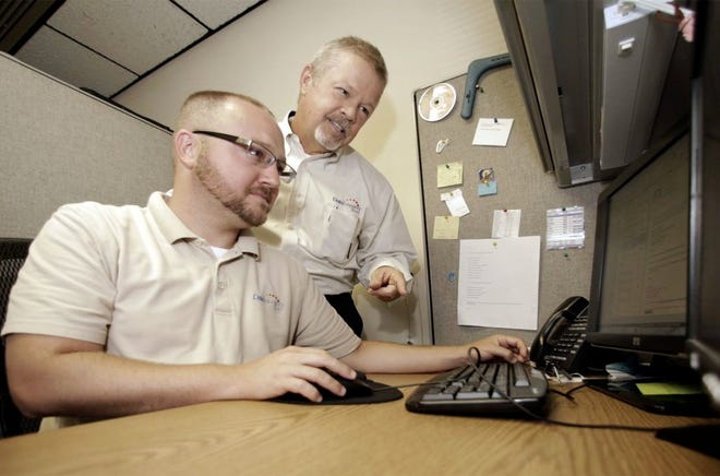 JOSH HEARD, vice president of operations, left, consults with his father at the company's Lakeland offices.