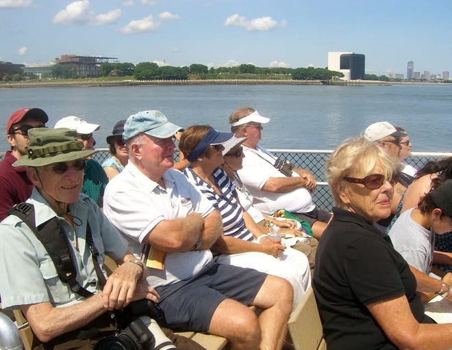 John Thompson, of Braintree, left front in hat, enjoys a cruise of the outer Boston Harbor Islands with the Friends of Boston Harbor Islands and UMass Boston OLLI students.
