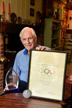 Stoneham native Donald Whiston poses for a photo with his Olympic diploma, his 1952 silver medal he had won as the men's hockey goalie in the Oslo Olympics, and his trophy he received when inducted into the Massachusetts Hockey Hall of Fame in 2012. To chronicle those events, Whiston, a former Brown University hockey coach and AD, has plans to write his memoirs about the many success stories he has had in and out of hockey. Wicked Local Staff Photo / David Sokol