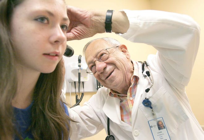 Dr. Louis Schaner checks the ears of patient Rebekah Stone, 12, of Massillon, at Akron Children’s Hospital Pediatrics in Perry Township. Dr. Schaner celebrates 50 years as a practicing pediatrician Tuesday.