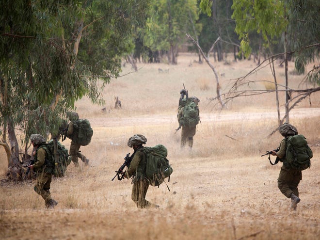 Israeli soldiers march during a drill near the Israel and Gaza border on Tuesday. Israeli airstrikes pummeled a wide range of targets in the Gaza Strip on Tuesday as the U.N. chief and the U.S. secretary of state began an intensive effort to end more than two weeks of fighting that has killed hundreds of Palestinians and dozens of Israelis.