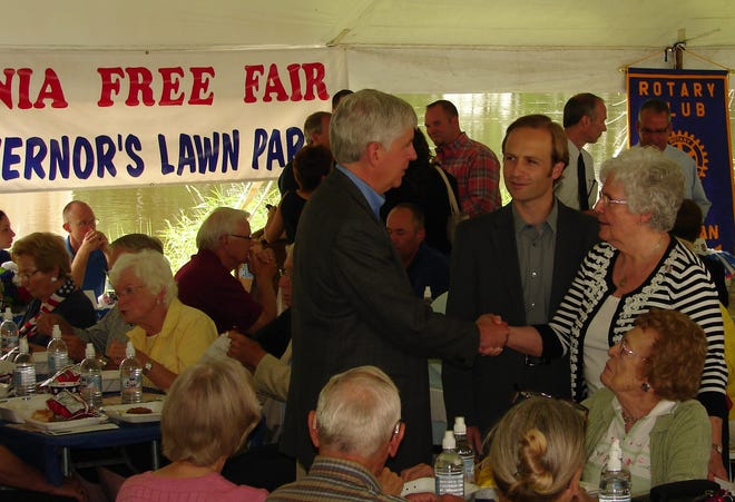 Governor Rick Snyder (left) and Lt. Gov. Brian Calley (center) visit with attendees at the Governor's Lawn Party at the Ionia Free Fair on Friday.