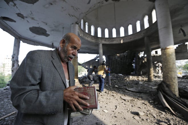 Palestinian Khaled Sharmi, 67, holds copies of the Quran, Islam's holy book, that he salvaged from a mosque in Gaza City that was destroyed by an Israeli airstrike.