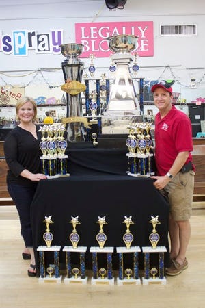 Linda and Larry Schexnaydre, owners of Center Stage Stars Company stand with their awards and two national titles earned from Access Broadway Cup Series in Orlando, Fla. earlier this month.