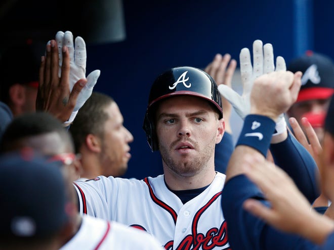 Atlanta Braves first baseman Freddie Freeman (5) celebrates in the dugout after hitting a three-run home run in the second inning against the Miami Marlins in Atlanta on Wednesday.