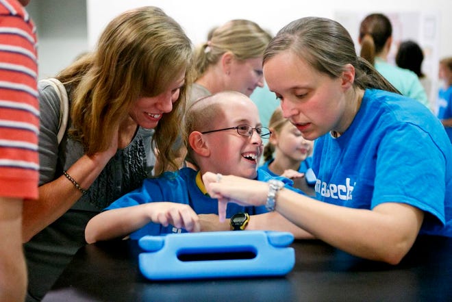 Alistair Jack, 8, shows his mom Trina Star and teacher Ashley Knarr the possibilities of iPads at a Technology night held at Morton High School.
