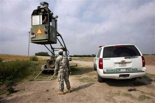 A member of the National Guard checks on his colleague inside a Border Patrol Skybox near the Hidalgo International Bridge in Hidalgo, Texas.