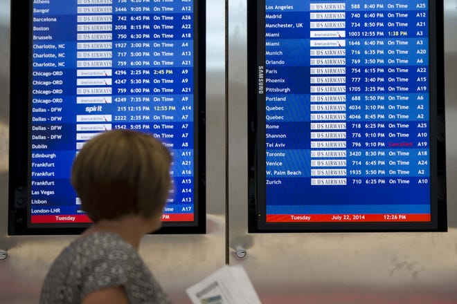 A woman passes by a departure board at the Philadelphia International Airport that shows that US Airways Flight 796 to Tel Aviv has been canceled, Tuesday, July 22, 2014, in Philadelphia. The Federal Aviation Administration has lifted its ban on U.S. flights in and out of Israel.