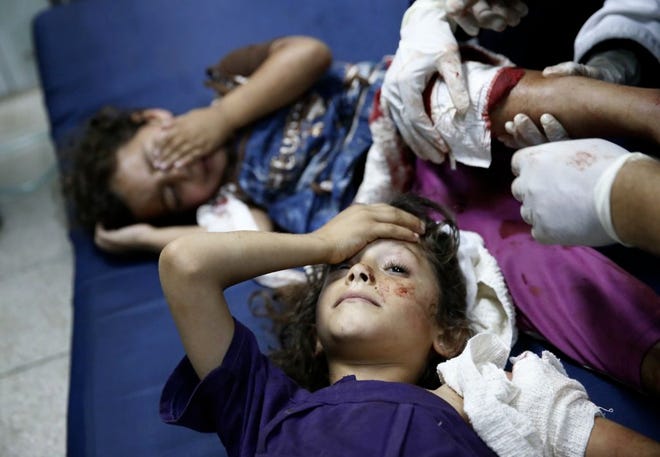 Palestinian children who were wounded in a strike on a compound housing a U.N. school in Beit Hanoun, in the northern Gaza Strip, are treated as they lie on the floor at the emergency room of the Kamal Adwan hospital in Beit Lahiya on Thursday.