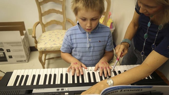 Larry Buchanan works on keyboard skills with Laurie McDonald at the Project Grow summer program in Lake Worth on July 14, 2014. (Bruce R. Bennett / The Palm Beach Post)