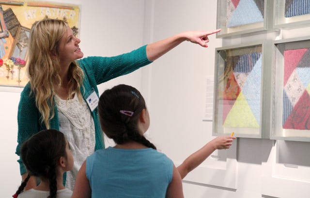 Rachel Rodemann • Times Record / Leah Sherry, art teacher at Trusty and Morrison elementary schools, helps children search for lines in art pieces at the Fort Smith Regional Art Museum, during the museum's It's An Art Party summer camp, Tuesday, July 22, 2014. 
 Rachel Rodemann • Times Record / Margaret Grubb, 7, holds her hand-made paper up to Glenna McBride, Tuesday, July 22, 2014, during paper-making art camp at the Fort Smith Regional Art Museum. McBride is a teaching artist with the Arkansas Arts Council.