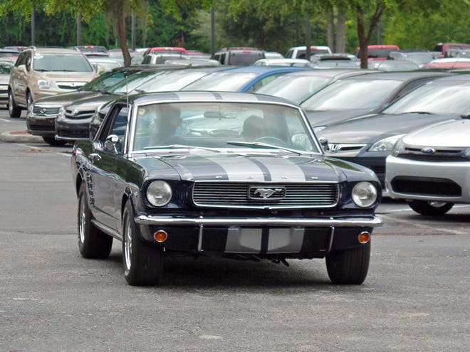Photo by Chris Brewer 12-year-old Will Yell gets a glimpse of the future - being behind the wheel of a 1966 Mustang after it was presented to him by his dad, Eddie. The surprise came during the inaugural cruise-in hosted by Sunshine State Chevelles and sponsored by Auction Direct at 6400 Blanding Blvd. last Saturday.