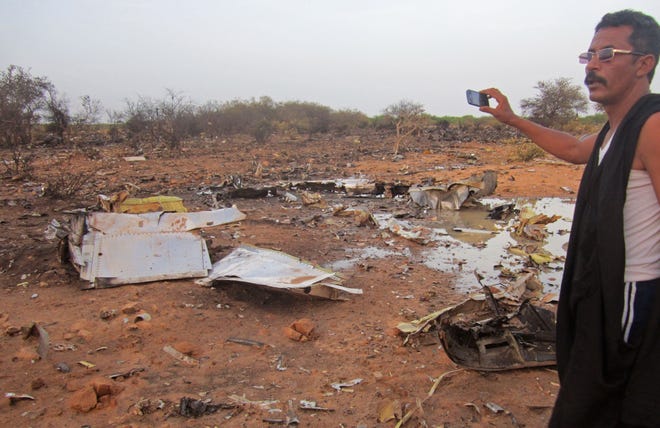 This photo provided on Friday, July 25, 2014, by the Burkina Faso Military shows a man at the site of the plane crash in Mali. French soldiers secured a black box from the Air Algerie wreckage site in a desolate region of restive northern Mali on Friday, the French president said. Terrorism hasn't been ruled out as a cause, although officials say the most likely reason for the catastrophe that killed all onboard is bad weather. At least 116 people were killed in Thursday's disaster, nearly half of whom were French.