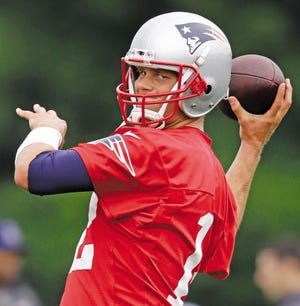 New England Patriots quarterback Tom Brady winds up for a pass during training camp at Gillette Stadium on Thursday.