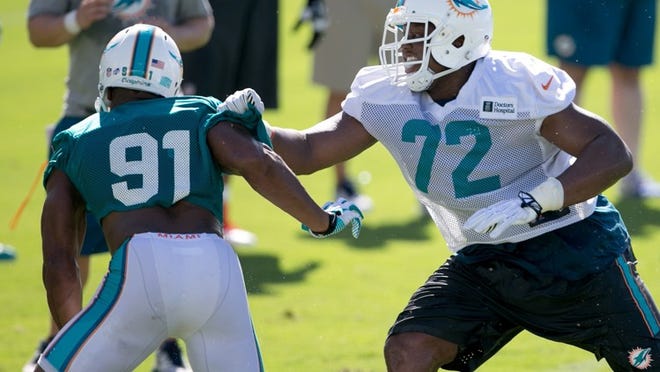 Rookie right tackle Ja’Wuan James, right, tries to fend off defensive end Cameron Wake at practice Friday. (Allen Eyestone / The Palm Beach Post)