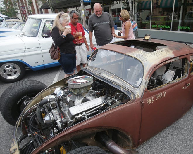 Couples sip beer while checking out an antique vehicle during Friday Fest in 2013.