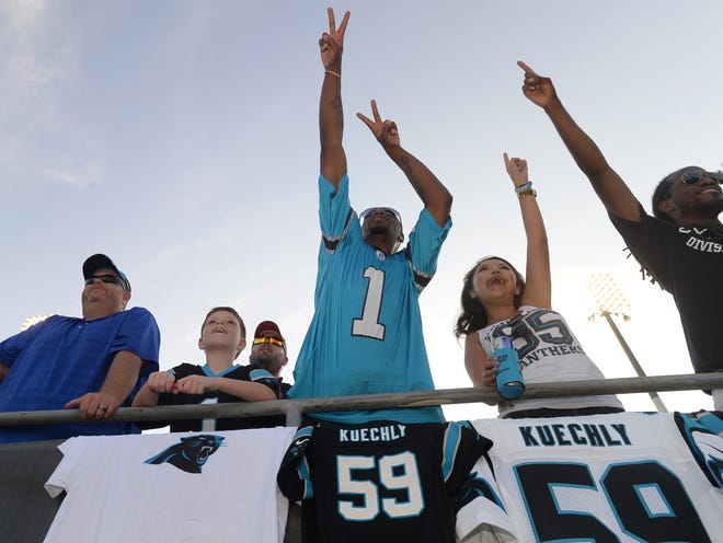 Carolina Panthers fan Antwon Harris of Spartanburg, wearing a Cam Newton jersey, reacts to a play on the field during the first training camp practice on Saturday evening.