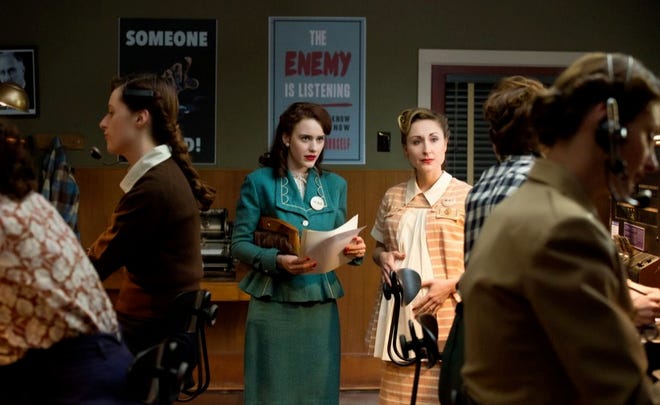 This photo released by WGN America shows, Rachel Brosnahan, center, as Abby Isaacs, in a scene from the TV series, "Manhattan." The show debuts 9 p.m. ET/8 p.m. CT, Sunday, July 27, 2014, on cable channel WGN America. The drama is set in a makeshift, desolate New Mexico desert community, one of several that sprang up as part of the Manhattan Project aiming to beat Nazi Germany to the bomb. (AP Photo/WGN America, Greg Peters)