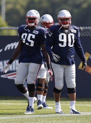 New England Patriots defensive end Chandler Jones (95) and linebacker Will Smith prepare to run a drill during an NFL football training camp in Foxborough, Mass., Saturday, July 26, 2014.