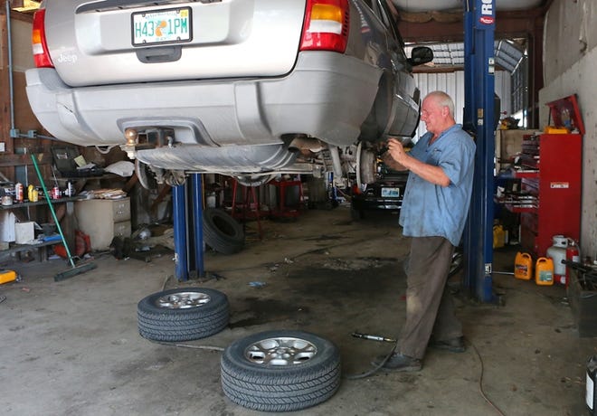 Charles Smith replaces a set of brake pads on a vehicle at C&J Automotive. The auto repair shop is located off State 390.