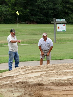 Jamie Mitchell • Times Record / Allen Shelton, left, Deer Trails construction superintendent, and Bobby Lewis, director of golf course operations, look over the foundation of the expanded practice putting green Sunday as work continues on expanding the green from 1,000 square feet to more than 3,500 square feet.