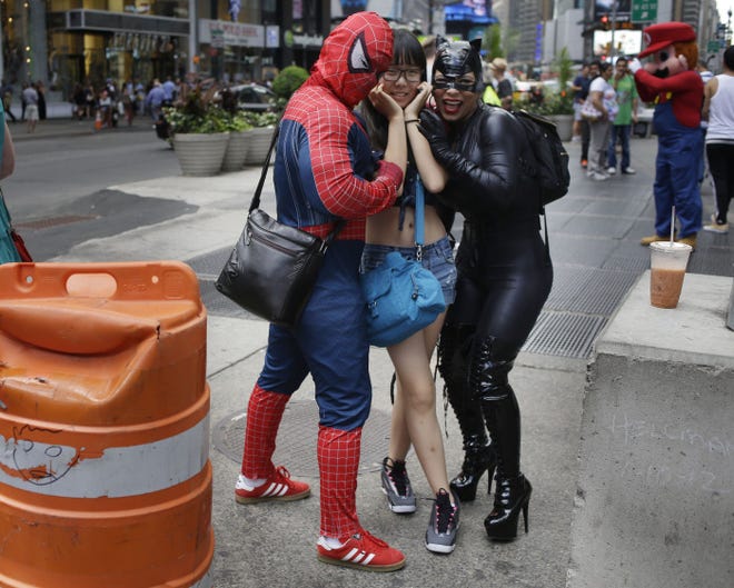 New York Mayor Bill de Blasio says the practice of costumed characters taking photos with tourists in Times Square has gone too far. The people dressed in costumes pose for photos with tourists in exchange for tips. The city council may require licenses and background checks for costumed performers. On Saturday, "Spider-Man" punched a police officer who told him to stop harassing tourists.