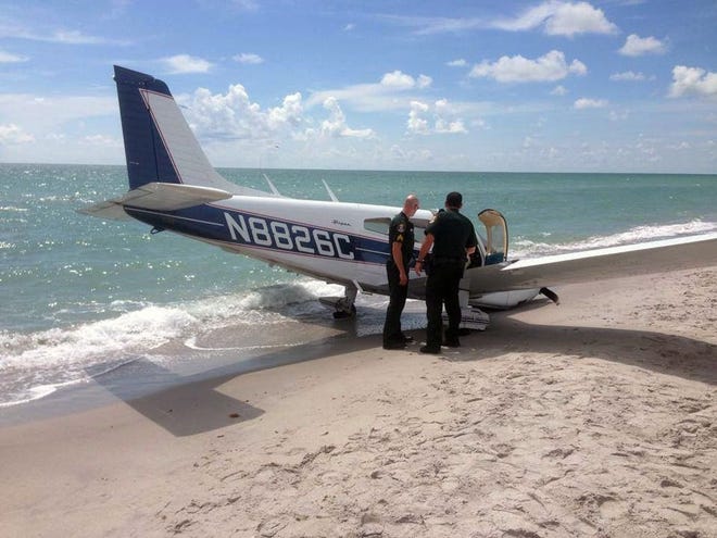 Emergency personnel at the scene of a small plane crash in Caspersen Beach in Venice, Sunday, July 27, 2014 . Authorities say a father was killed and his daughter seriously injured while walking on the sand when a small plane crash landed along Florida’s Gulf Coast near Venice Beach.