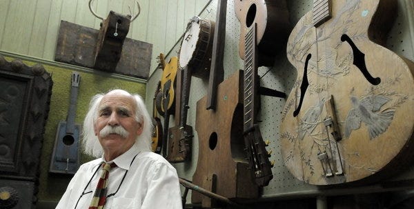 DENNIS -- 073014 -- Morgan Rank sits among some of the folk art and instruments that are part of his collection at Eldred's auction house.