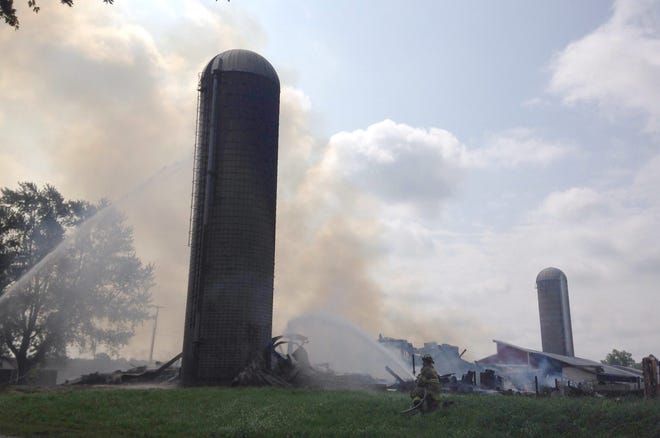 Firefighters extinguish a barn fire in Overisel Township at the corner of 144th Avenue and 43rd Street on Wednesday morning. Lisa Ermak/Sentinel staff