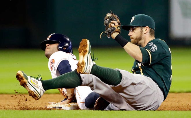 Houston Astros' Jose Altuve, left, is tagged out by Oakland Athletics second baseman Eric Sogard, right, while trying to steal second base during the fifth inning of a baseball game Tuesday, July 29, 2014, in Houston. (AP Photo/David J. Phillip)
