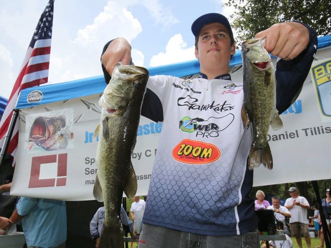 Zach Thompson, 14, shows off his largemouth bass as he has his picture taken during the weigh-in for the Junior Bassmasters Challenge on Lake Kerr in the Ocala National Forest on Saturday, July 26, 2014.