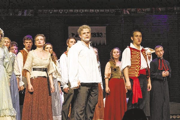 In foreground, from left, Eponine (Rebecca Brudner), Valjean (Bruce Barger) and Enjolras (Nick Martiniano) are joined by the ensemble in “Les Misérables.”