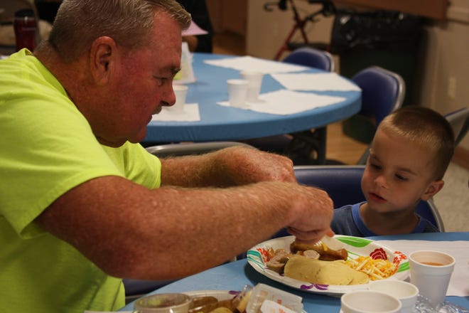 Grandpa Steve McNally helps his grandson, Matthew McNally with his breakfast at Deltona’s 4th Annual Senior Breakfast at the Deltona Sunshine Community Center.