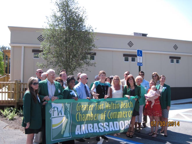 Ribbon cutting: Surrounded by Fort Walton Beach Chamber of Commerce ambassadors and other civic and local dignitaries, Dr. Karen Chapman, director of DOH-Okaloosa, cut the ribbon during the Florida Department of Health in Okaloosa County’s grand opening celebration for its new Clinic Annex.
