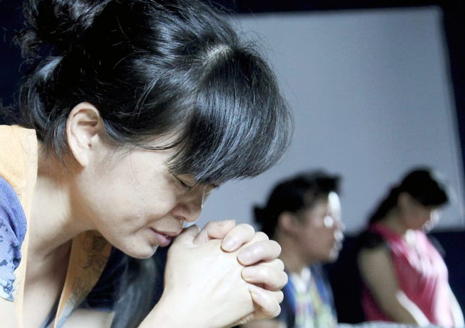 In this photo taken July 16, church members pray in a private room in Jiu'en Tang, a Christian church, in the Shuitou township in Wenzhou in eastern China's Zhejiang province. Across Zhejiang province, which hugs China’s rocky southeastern coast, authorities have toppled, or threatened to topple, crosses at more than 130 churches. AP PHOTO/DIDI TANG