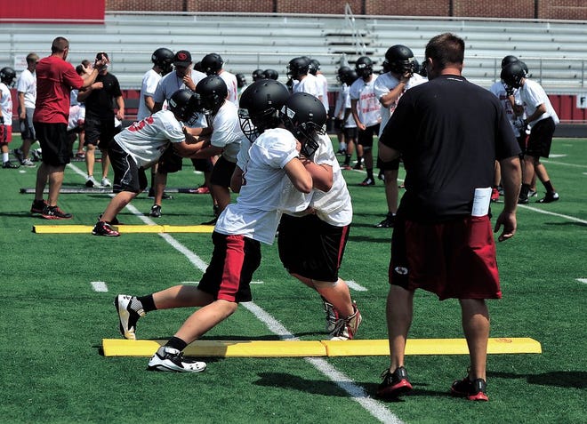 New Philadelphia players work on lineman drills during Friday’s practice at Woody Hayes Quaker Stadium.