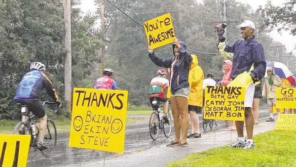 Geoff Worrell and his daughter, Lindsay, stand in the rain all day Saturday to cheer on participants of the Pan-Mass Challenge. Worrell's wife, Cindy, is a two-time cancer survivor, an inspiration to her family and a die-hard supporter of the annual ride.