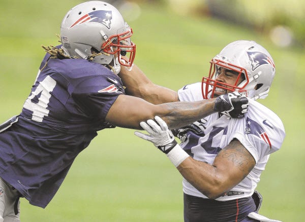 New England Patriots outside linebacker Dont'a Hightower, left, grapples with tight end D.J. Williams, right, during a field exercise at an NFL football training camp practice at Gillette Stadium, Sunday, July 27, 2014, in Foxborough, Mass.