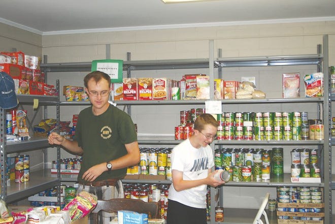 Bryan Larew and Christopher Bryan help stock the Greencastle food pantry shelves. Youth often help out as part of their community service projects.
