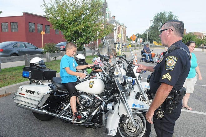 Anthony Gabriel sits on a Taunton police motorcycle as Sgt. Colby Crossman tells him about the bikes during Taunton's first National Night Out on Aug. 7, 2012.
